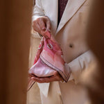 Man holding a pink handkerchief with a geometric design